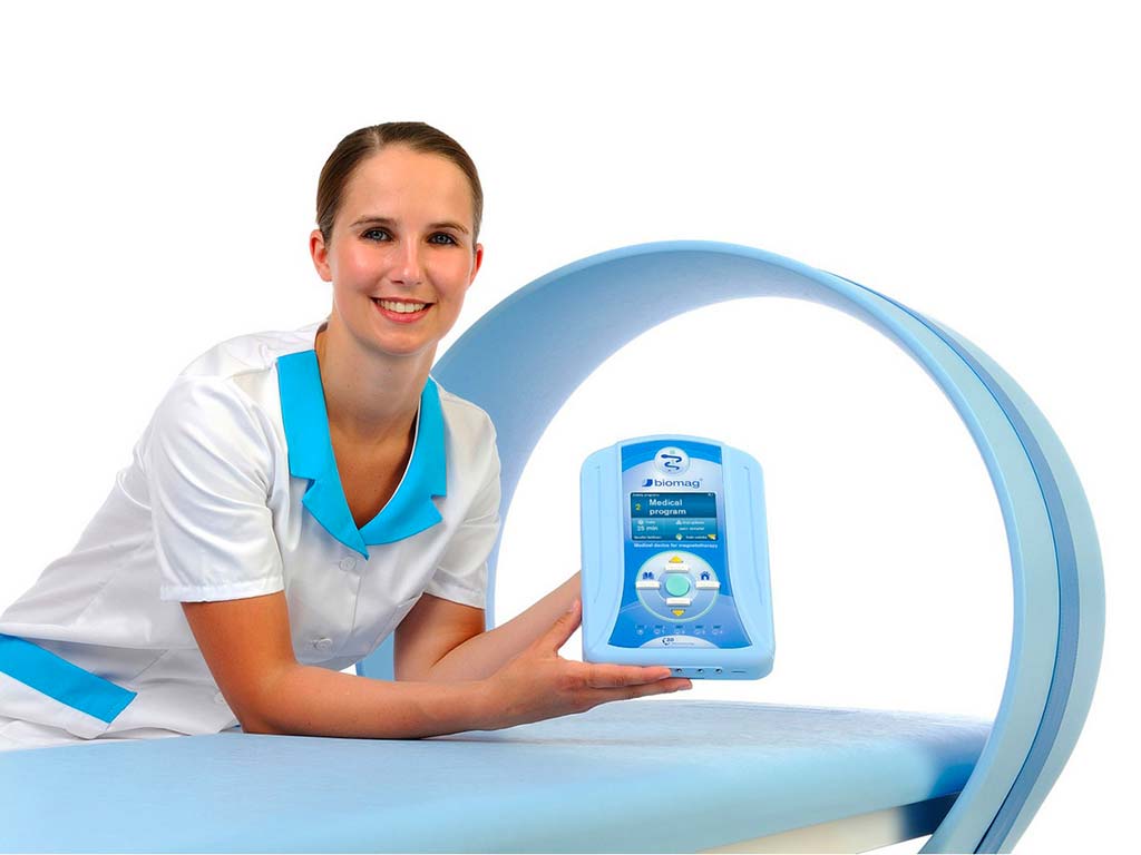 Ärztin mit Magnetfeldtherapie Steuergerät vor eine Spule